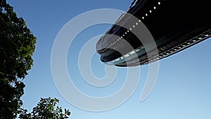 Viking boat in a fairground attraction, seen from below, with blue sky day background