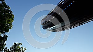 Viking boat in a fairground attraction, seen from below, with blue sky day background