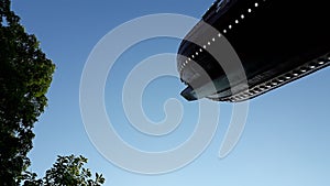 Viking boat in a fairground attraction, seen from below, with blue sky day background