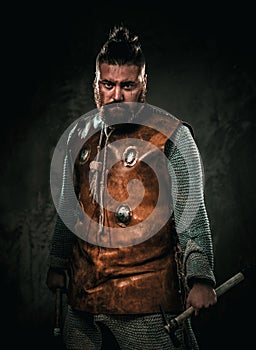 Viking with cold weapon in a traditional warrior clothes