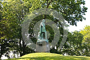 Viking Gange-Rolf statue who was a Viking Chief, which is a Bronze statue surrounded by trees in Alesund Park, Alesund, Norway photo