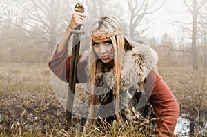Viking girl with sword in a fog