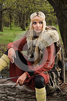 Viking girl with sword in a wood