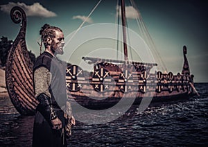 Viking warrior standing near Drakkar on seashore