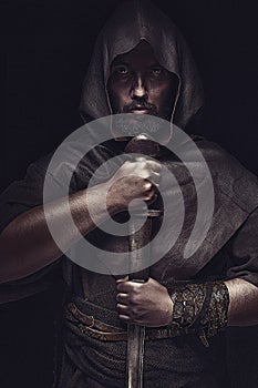 Viking warrior with sword over black background holding sword