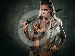 Viking woman with cold weapon in a traditional warrior clothes