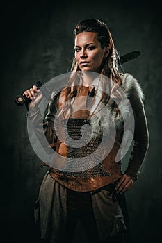 Viking woman with cold weapon in a traditional warrior clothes