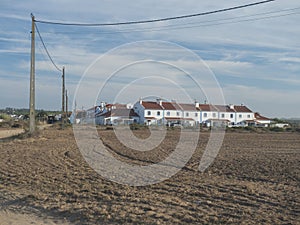 Vila Nova de Milfontes, Portugal, October 25, 2021: View over field to Vila Nova de Milfontes white and blue houses in