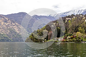 Villa in Como lake Italy with snow and mountain looking from boat in Lenno