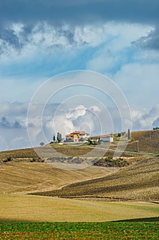 Villa in Italy, old farmhouse in the waves of tuscanian fields and hills