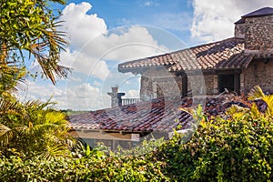 Villa with a red roof in the jungle. Old European-style house in tropical latitudes. Living in wild. Brick house in the tropics.