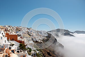 Village above clouds. View of Oia village, Santorini caldera, Greece.