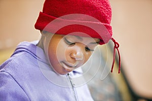 village african girl with red beanie sited on the bench