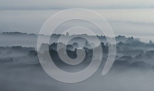 Village buildings houses and trees in low lying dense fog clouds moody morning haze in Gemeinlebarn Lower Austria