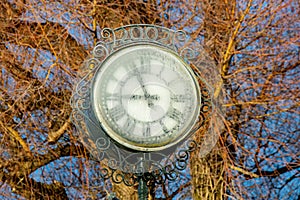 A village clockface is frozen in the winter frost,