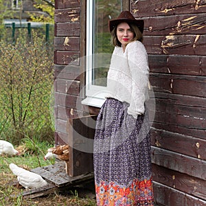 A village girl is standing in a cowboy hat