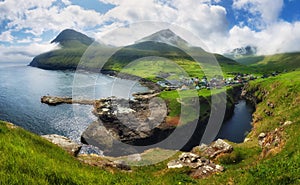 Village of Gjogv on Faroe Islands with colourful houses. Mountain landscape with ocean coast