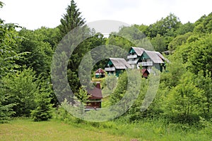 Village  green landscape. Cottage at the beautiful mountains background