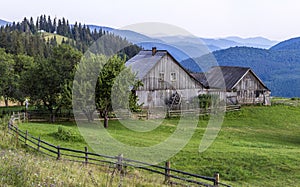 Village houses on hills with green meadows in summer day. House