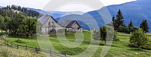 Village houses on hills with green meadows in summer day. House