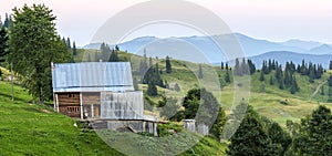 Village houses on hills with green meadows in summer day. House