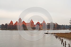 Village of Karaites, Lithuania, Europe. Lithuanian landmark in late autumn. Girl standing on the pier and taking photos on her pho