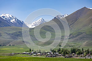 The village of Kyzyl Tuu with the Tian Shan Mountains in the background in Kyrgyzstan