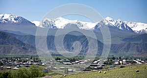 The village of Kyzyl Tuu with the Tian Shan Mountains in the background in Kyrgyzstan