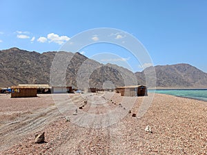 Village landscape on the Sinai coast with desert mountains and turquoise waters. Remote and arid landscapes