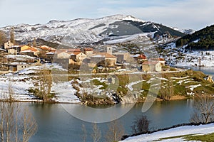 Village of mountain snow on the slope of a reservoir in winter photo