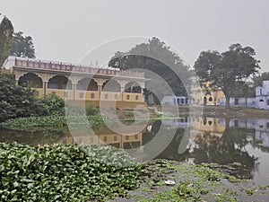 This is a village pond in india ,muslim paryer is seen across the pond