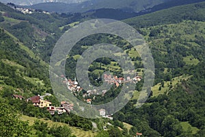 Village with red roofed houses in the wooded mountains in Kosovo