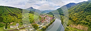 Village, river and road in mountain valley. Green mountain meadows and hills. KraÄ¾oviansky meander on river Bar. Spring panorama