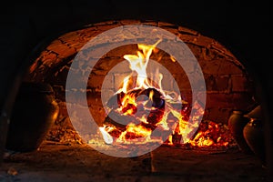 Village stove firewood and fire. Burning wood inside traditional oven