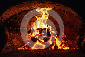 Village stove firewood and fire. Burning wood inside traditional oven