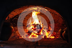 Village stove firewood and fire. Burning wood inside traditional oven