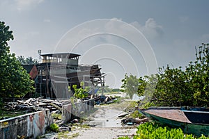 Village street with muddy road and broken boat at the Fenfushi island