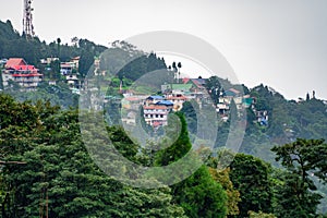 Village town of shimla darjeeling ghum ghoom on top of mountain with trees in front and mists rolling by