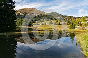 Village of Valbella reflected in mountain lake in the Swiss Alps