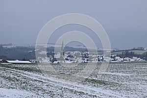 village Welling with the dark church tower during winter snow photo