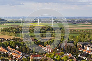 Village and wind turbines in flat landscape