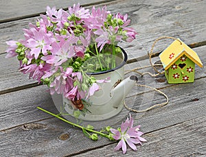 Villatic still life with of pink mallow on a wooden background photo