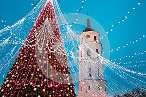Vilnius, Lithuania. Christmas Tree On Background Bell Tower Belfry Of Vilnius Cathedral In Evening New Year Christmas