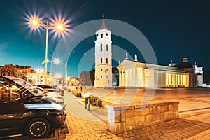 Vilnius, Lithuania, Eastern Europe. Cars Parked Near Square With Bell Tower Belfry, Cathedral Basilica Of St. Stanislaus
