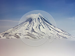 Vilyuchinsk volcano covered by snow with clouds below