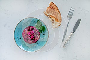 Vinaigrette salad with boiled vegetables, pickled cucumbers, sauerkraut and canned greens isolated on white. Vegetarian food.