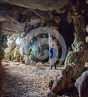 Man stands in Santo TomÃÂ¡s Cave, visible from shaft of light fro
