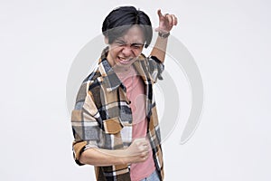 A vindicated young asian man celebrating, grooving and jiving. Feeling amped and stoked. Isolated on a white background