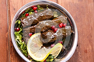 Vine leaves with lemon served in dish isolated on background top of arabic food cold mezza photo