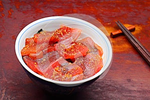 Vinegared rice topped with sliced raw tuna photo